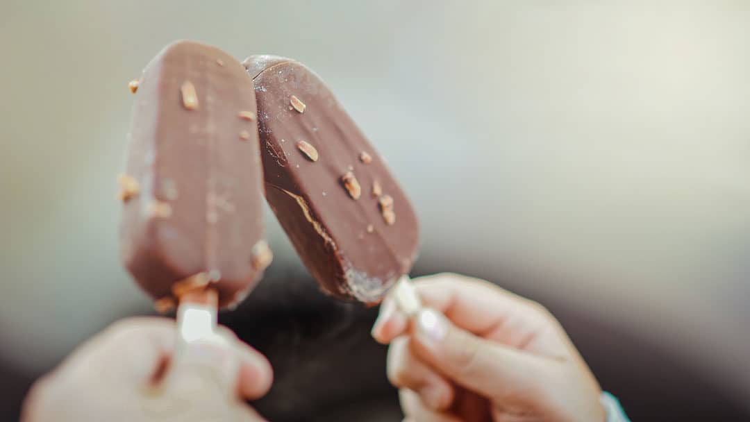 Hands Holding Popsicles in the Summer Heat