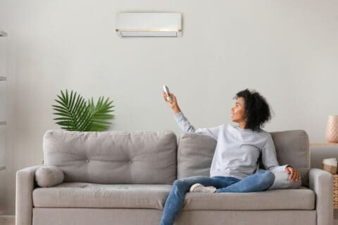 Woman sitting in front of a Mitsubishi Mini-Split Ductless System