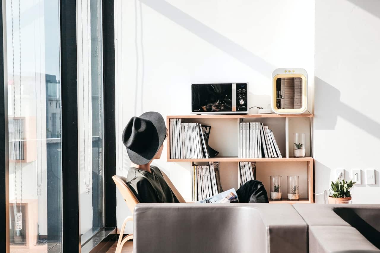 Person sitting in a clean living room enjoying improved indoor air quality with air purification and ventilation systems.