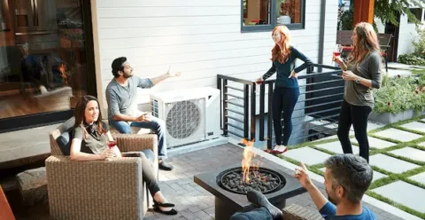 People sitting outside around a Daikin Fit air conditioner
