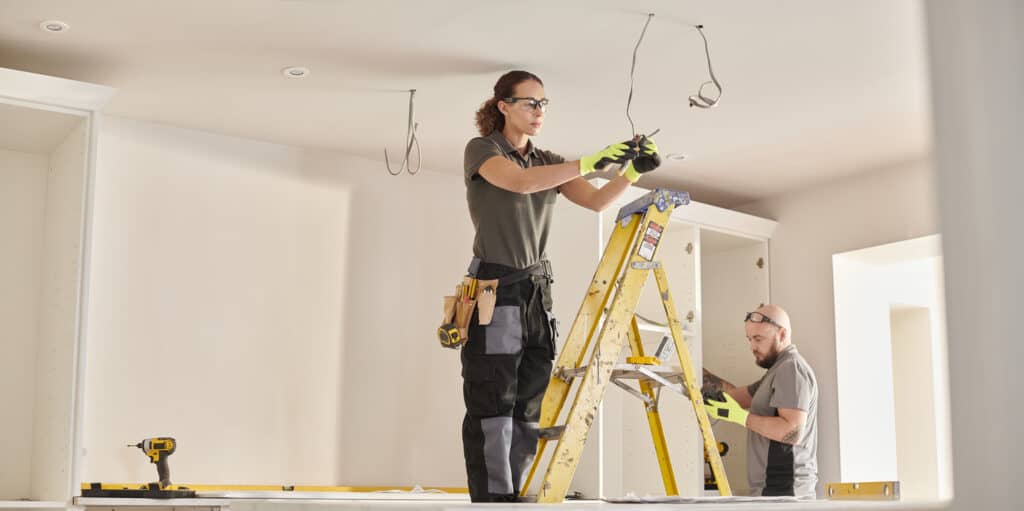 female electrician working in a kitchen remodelling
