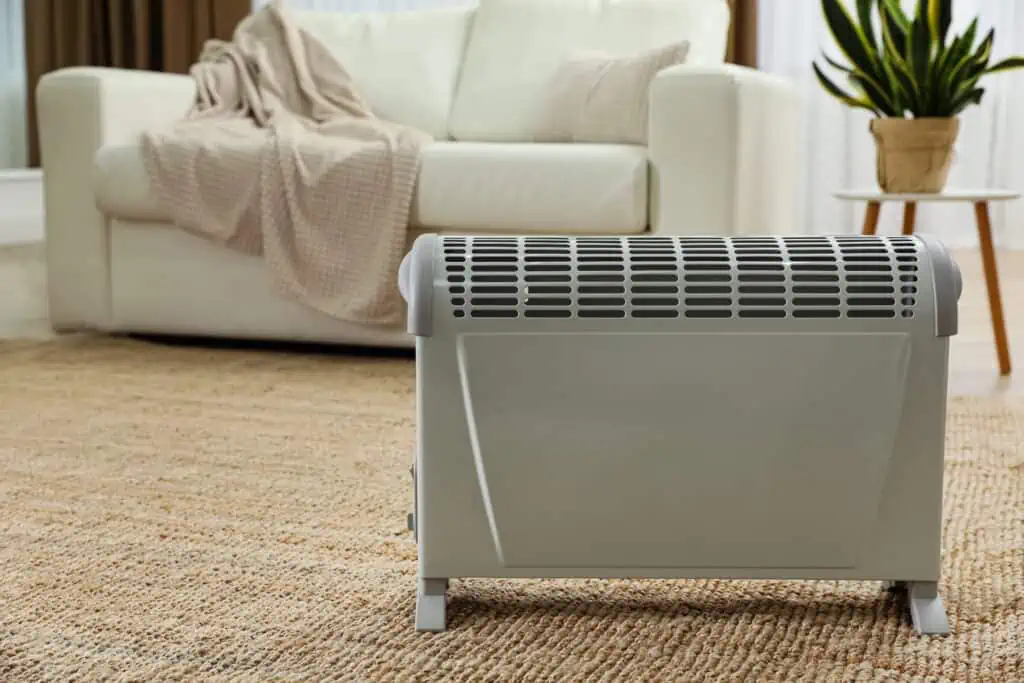 Compact space heater on the floor providing additional warmth in a well-decorated living room, ensuring comfort during cold weather.