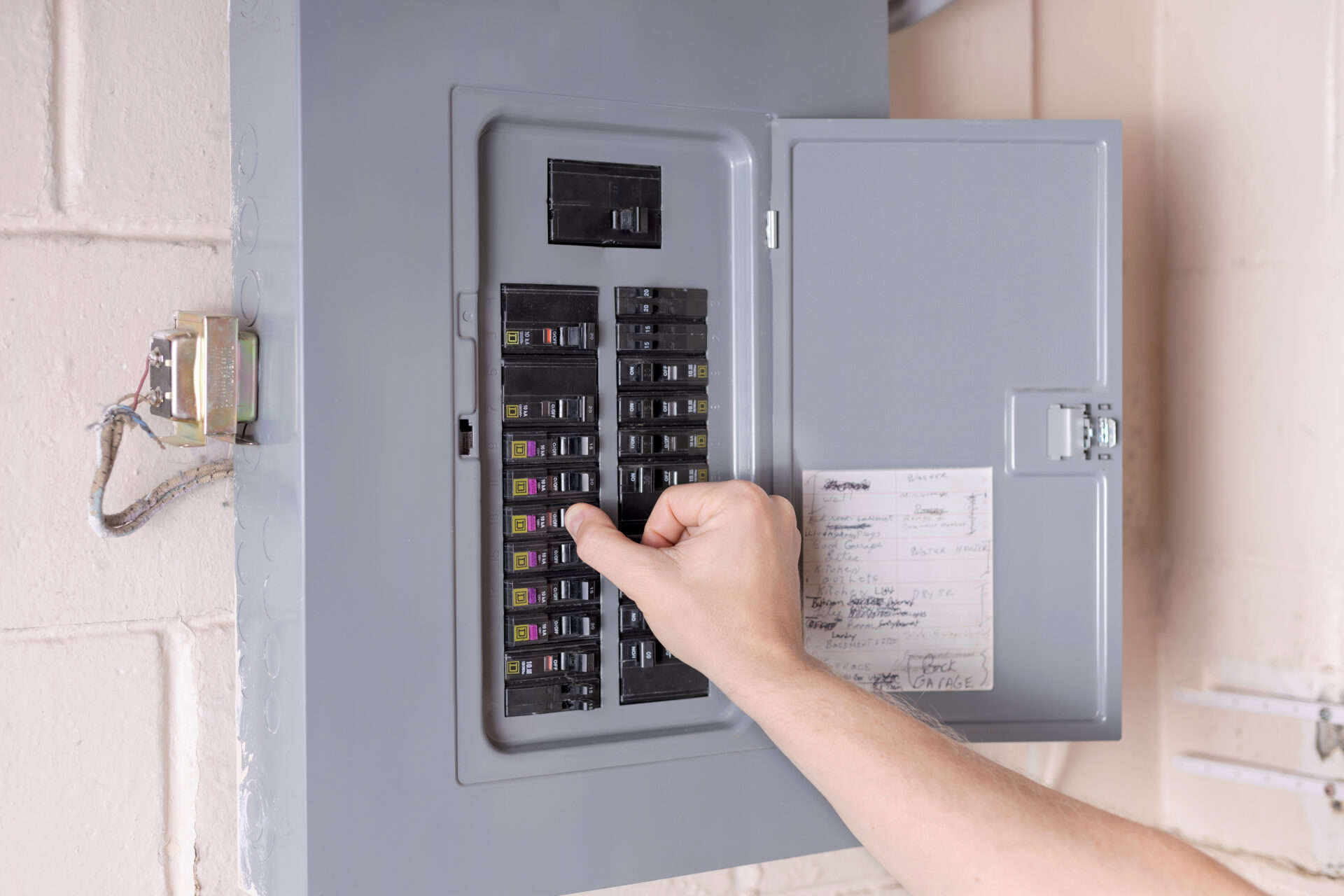 Homeowner adjusting a circuit breaker in an electrical panel for enhanced safety and reliability.